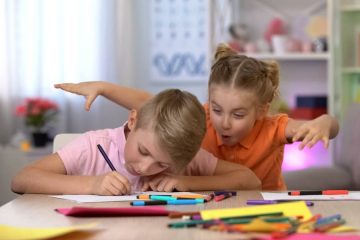 menina assustando menino enquanto ele estuda