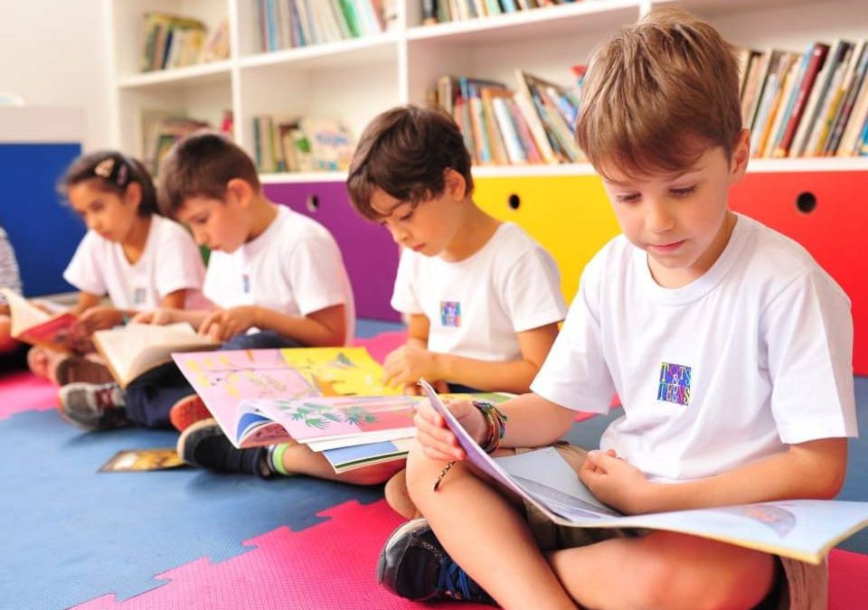 Crianças dentro da sala de aula de uma escola internacionakl lendo livros
