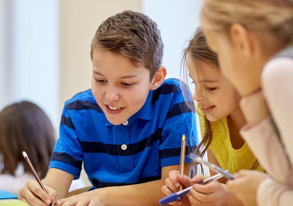 Menino e duas meninas fazendo atividade escolar juntos