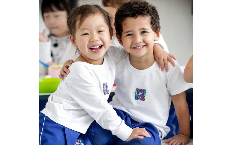 Menino e menina abraços e sorrindo para quem está tirando a foto